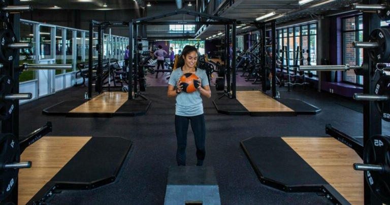 A young women exercises with a ball.